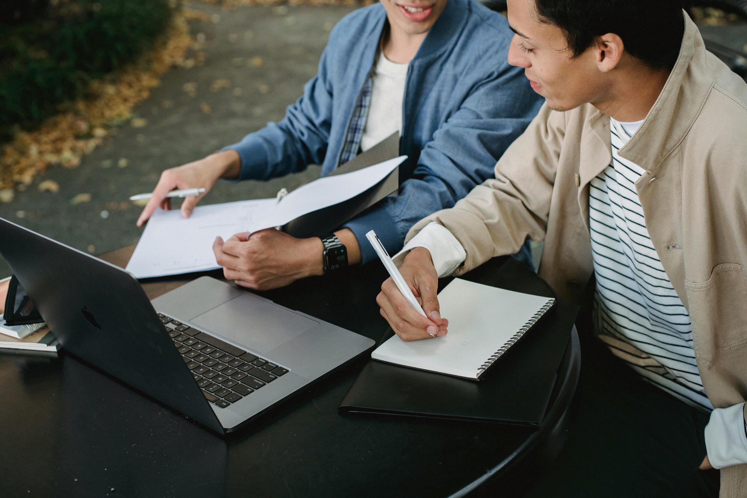 Two students reviewing an application file next to a laptop